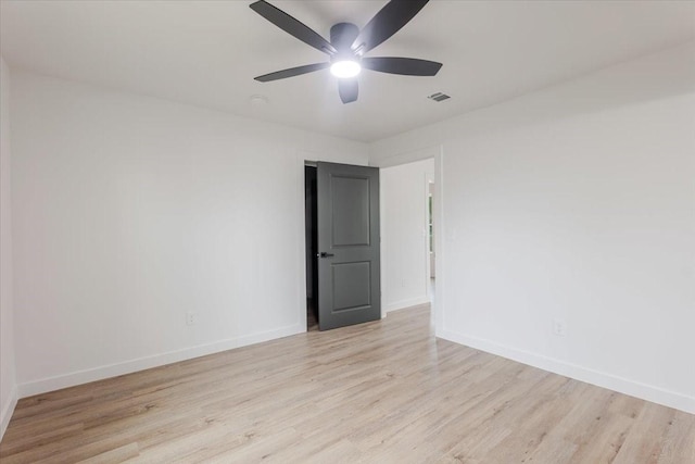 unfurnished room with baseboards, a ceiling fan, wood finished floors, and visible vents