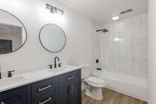 full bath featuring a sink, toilet, wood finished floors, and visible vents