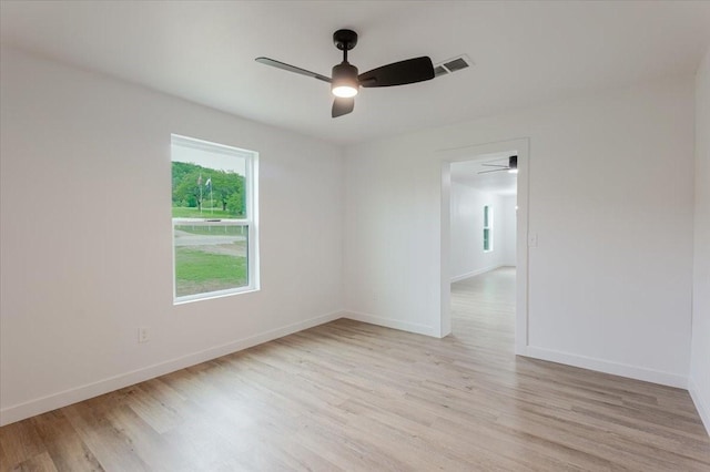unfurnished room featuring baseboards, a ceiling fan, light wood-type flooring, and visible vents