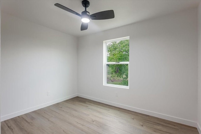 spare room with baseboards, a ceiling fan, and light wood-type flooring