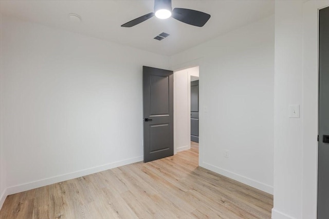 empty room featuring visible vents, light wood-style flooring, baseboards, and ceiling fan