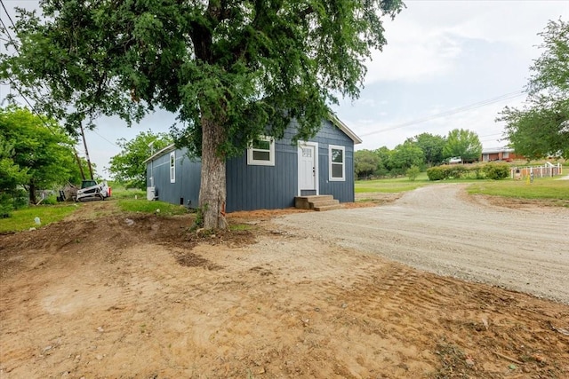 view of property exterior with driveway and entry steps
