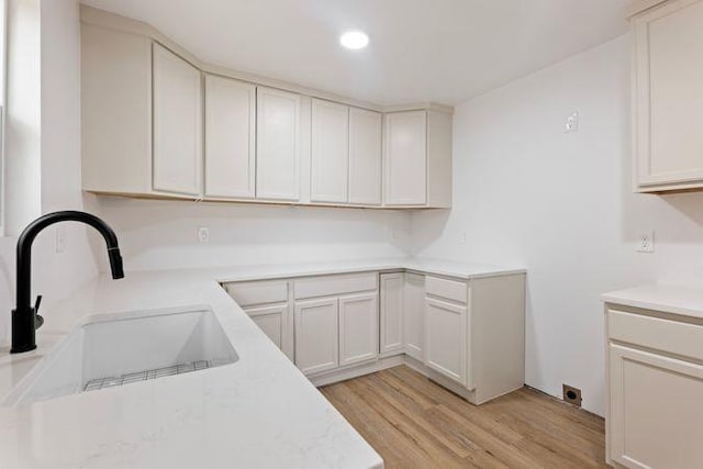 kitchen featuring recessed lighting, a sink, and light wood-type flooring