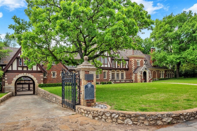 8 Westover Rd, Westover Hills, TX 76107 - tudor home with concrete driveway, stone siding, a gate, and a front yard