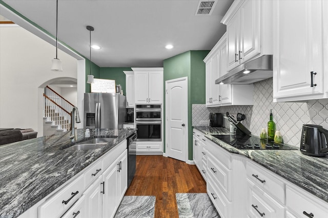 kitchen featuring visible vents, under cabinet range hood, white cabinets, a sink, and black appliances