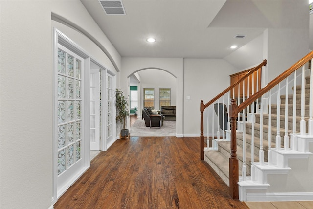 foyer entrance featuring arched walkways, visible vents, and recessed lighting