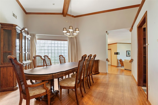dining area featuring visible vents, crown molding, an inviting chandelier, beamed ceiling, and light wood finished floors