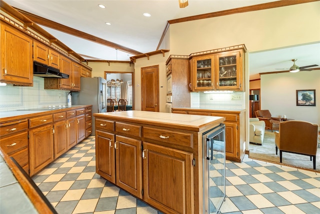 kitchen with wine cooler, crown molding, tile counters, and under cabinet range hood