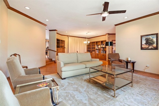 living area with ornamental molding, ceiling fan with notable chandelier, recessed lighting, and wood finished floors