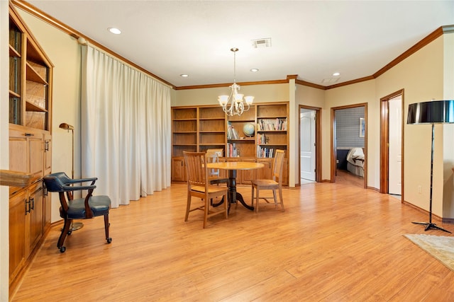 dining area with crown molding, visible vents, light wood-style flooring, and an inviting chandelier