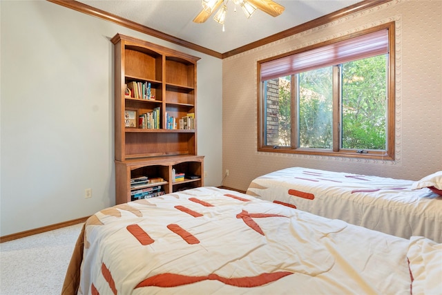 carpeted bedroom featuring ornamental molding, ceiling fan, and wallpapered walls