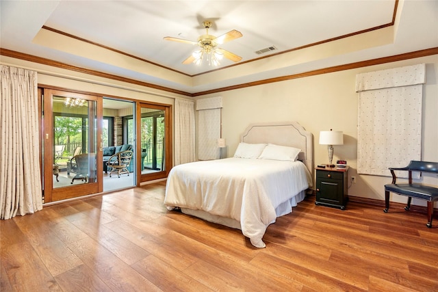 bedroom with visible vents, ornamental molding, access to exterior, light wood-style floors, and a raised ceiling