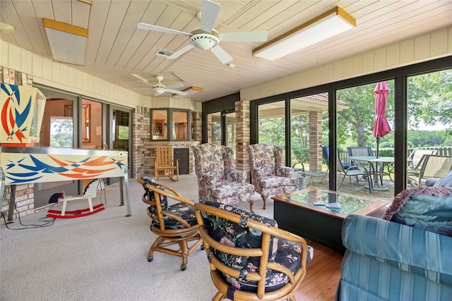 sunroom / solarium with outdoor dining area, an outdoor living space, ceiling fan, and visible vents