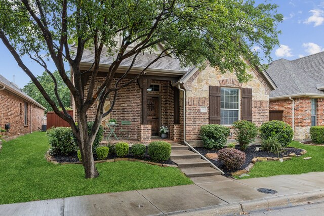 5312 Oakley Rd, Mckinney, TX 75070 - english style home featuring a front lawn, brick siding, and a shingled roof