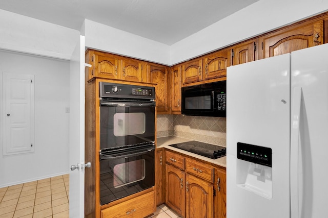 503 Bluebonnet Ln, Red Oak, TX 75154 - kitchen featuring baseboards, light countertops, brown cabinets, tasteful backsplash, and black appliances