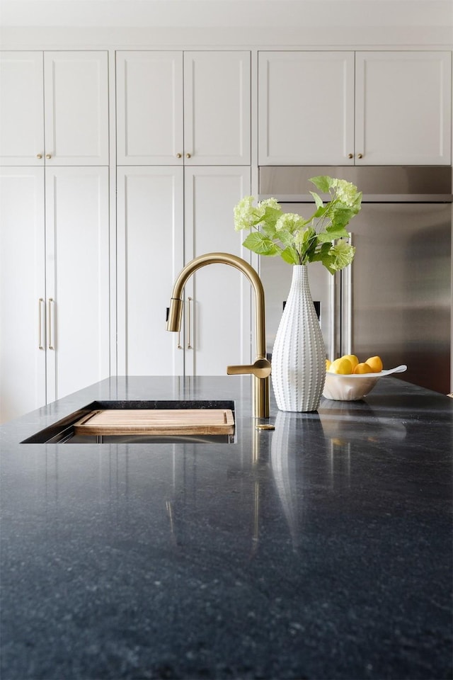 room details with dark stone counters and white cabinetry
