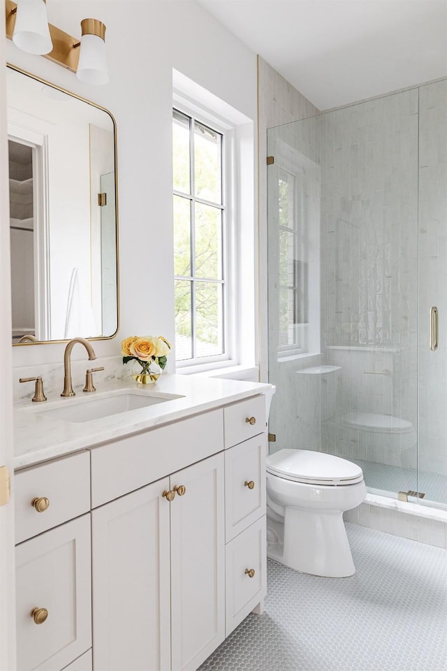 full bath featuring vanity, tile patterned flooring, a stall shower, and toilet