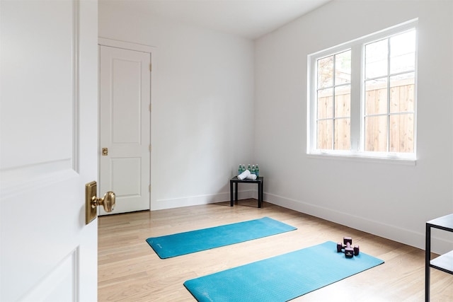 exercise area featuring baseboards and wood finished floors