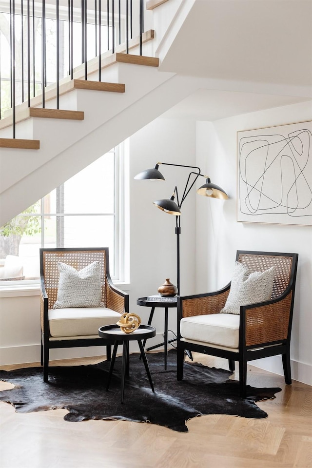 sitting room featuring baseboards and stairs