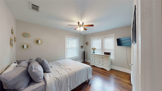 bedroom featuring baseboards, ceiling fan, dark wood-style flooring, and visible vents