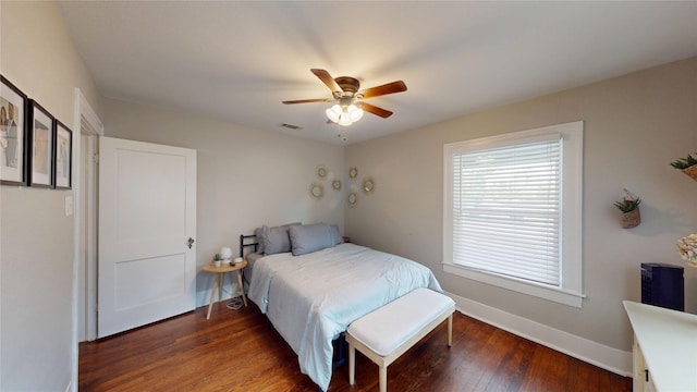 bedroom featuring a ceiling fan, baseboards, visible vents, and wood finished floors