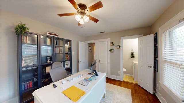 office with visible vents, a ceiling fan, dark wood finished floors, and baseboards