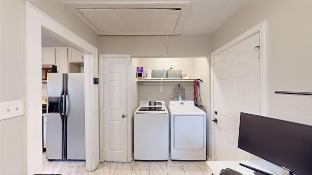 washroom featuring laundry area, washing machine and dryer, and attic access