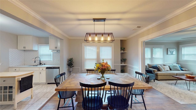 dining space featuring visible vents, ornamental molding, and light wood finished floors