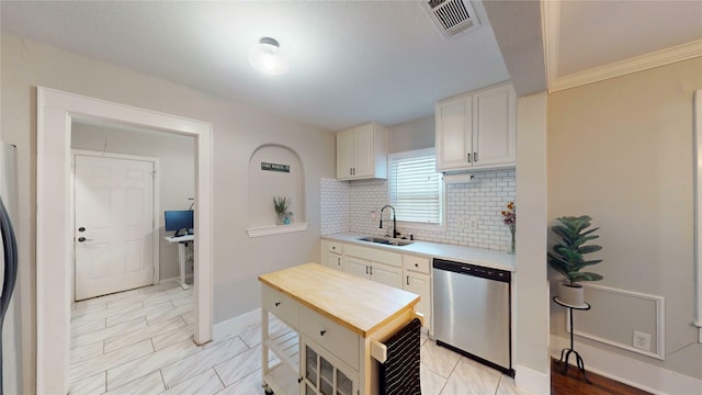kitchen with visible vents, decorative backsplash, baseboards, a sink, and stainless steel appliances