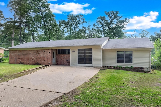 single story home featuring brick siding, driveway, and a front yard