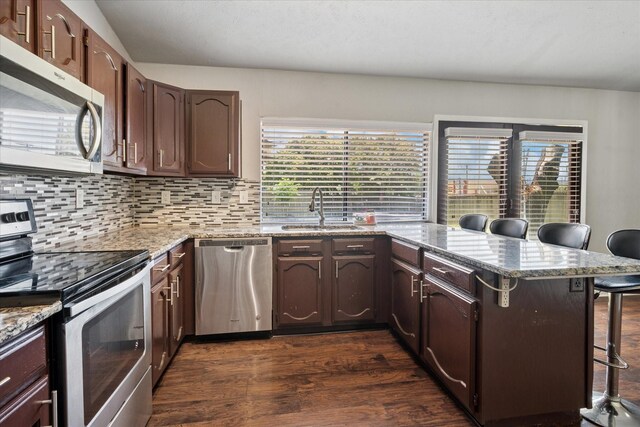 2036 Apple Valley Rd, Plano, TX 75023 - kitchen featuring a kitchen breakfast bar, backsplash, a sink, a peninsula, and stainless steel appliances