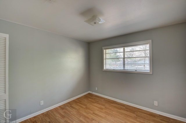 spare room with baseboards and light wood-style flooring