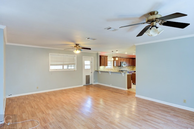 unfurnished living room featuring crown molding, ceiling fan, visible vents, and light wood-style floors