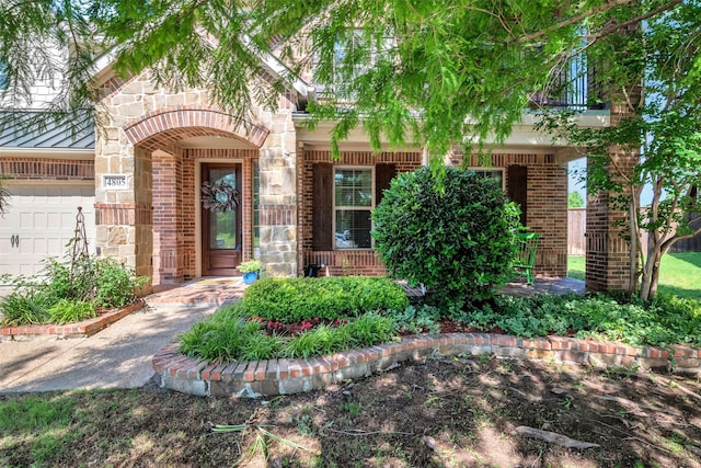 property entrance featuring stone siding, brick siding, and a garage
