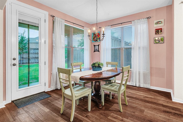 dining space with baseboards, a wealth of natural light, and an inviting chandelier