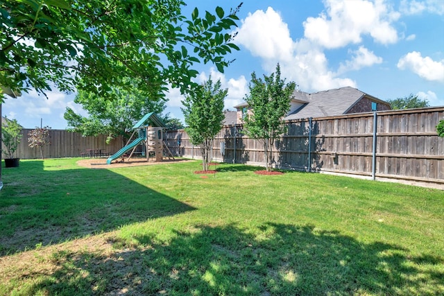 view of yard featuring a fenced backyard and a playground