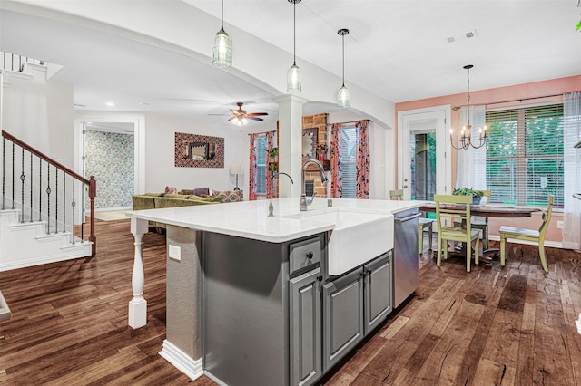 kitchen with a sink, visible vents, dark wood finished floors, stainless steel dishwasher, and gray cabinetry