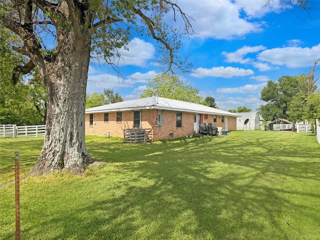 back of house with fence, a yard, and brick siding