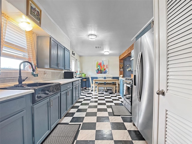 kitchen with backsplash, visible vents, a sink, light countertops, and stainless steel appliances