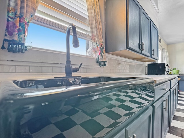 kitchen with a healthy amount of sunlight, decorative backsplash, and a sink