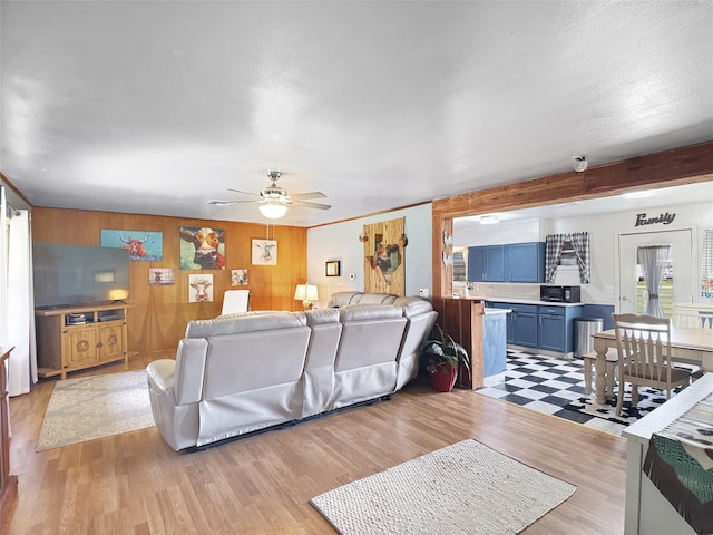 living area with ceiling fan and light wood-style floors