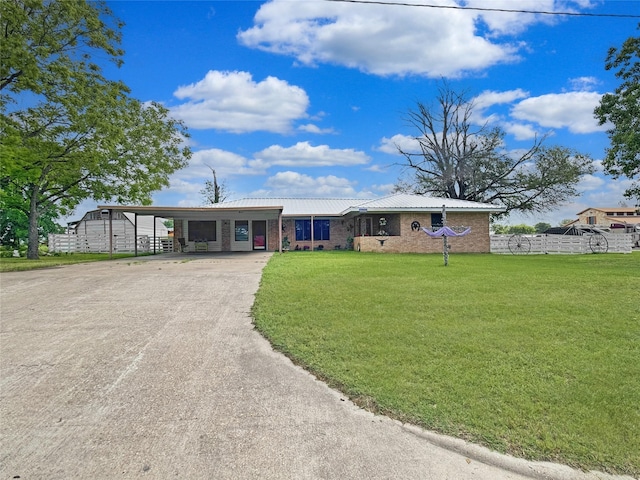 single story home featuring fence, a front yard, an attached carport, metal roof, and driveway