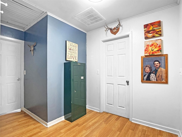 interior space featuring crown molding, baseboards, visible vents, and light wood finished floors