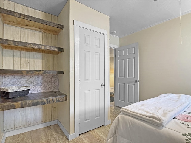 bedroom featuring light wood-style floors and baseboards