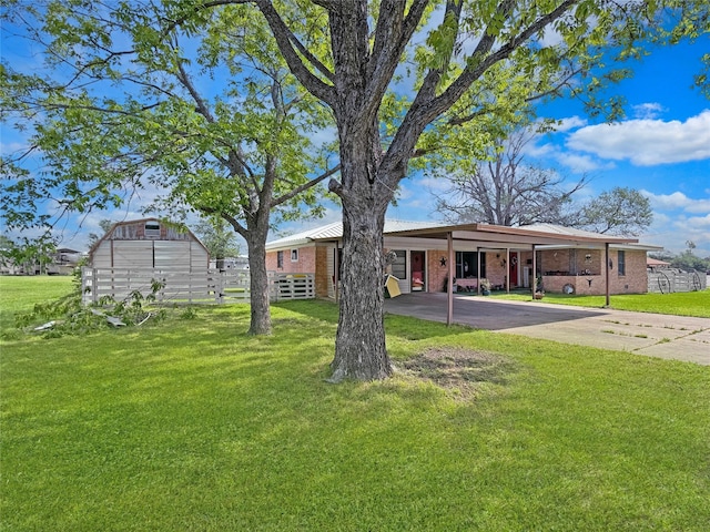 view of front facade featuring concrete driveway, an attached carport, a front lawn, and brick siding