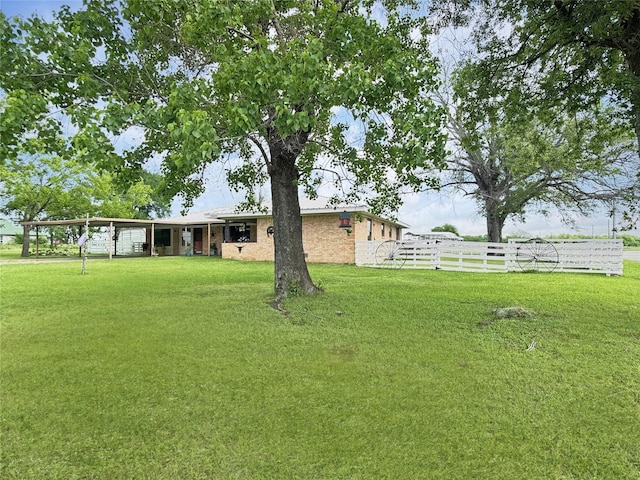 view of yard with fence and a carport