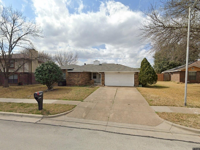 single story home featuring an attached garage, a front lawn, brick siding, a chimney, and driveway