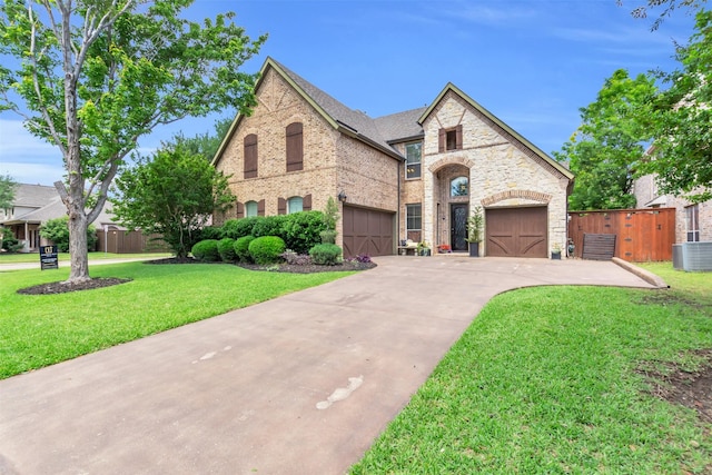 15604 Christopher Ln, Frisco, TX 75035 - french country inspired facade with central AC, driveway, a garage, brick siding, and stone siding