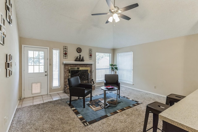 living area with a wealth of natural light, vaulted ceiling, and a fireplace