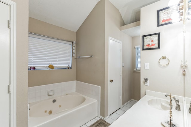 bathroom with tile patterned floors, a sink, and a jetted tub